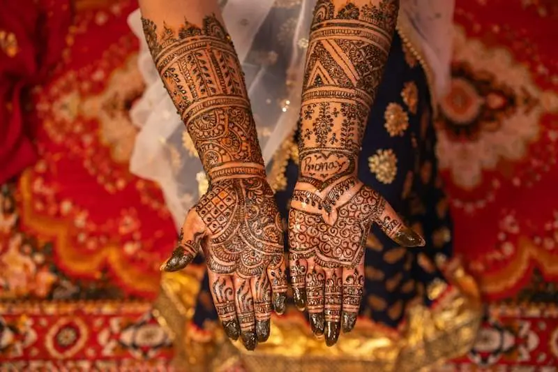 Hennaed hands on a red cloth
