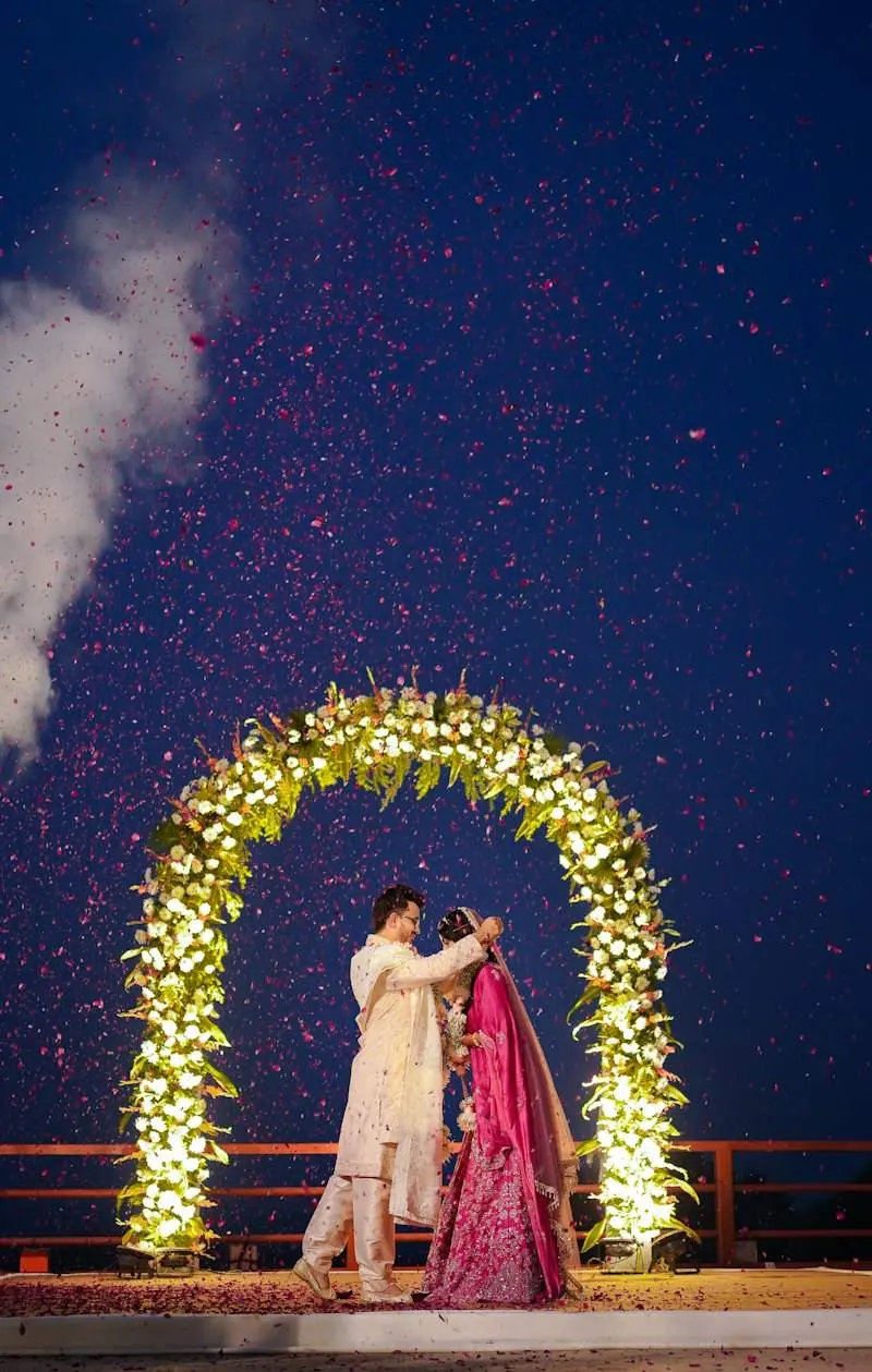 The couple under a floral arch at night